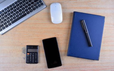 Klavye ve fare, dolma kalem, defter, hesap makinesi ve smartphone bir tablo