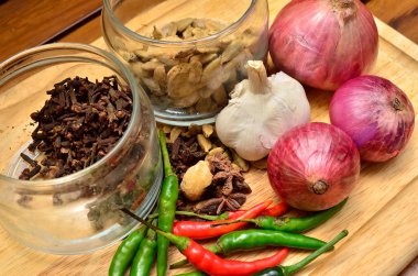 Pişirme malzemeleri. Baharat ve otlar ile soğan ve sarımsak ahşap tahta üzerinde