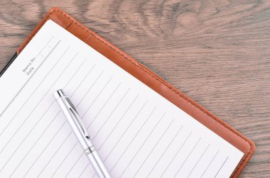 Kalem ve ahşap masa üstünde not etmek