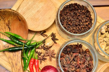 Pişirme malzemeleri. Baharat ve otlar ile soğan ve sarımsak ahşap tahta üzerinde