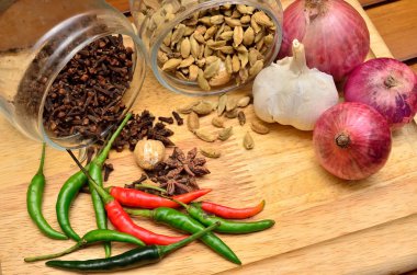 Pişirme malzemeleri. Baharat ve otlar ile soğan ve sarımsak ahşap tahta üzerinde
