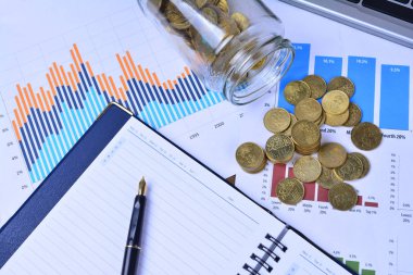 Grafikler, çizelgeler, defter, kalem ve paralar. İş kavramı