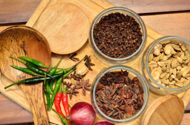 Pişirme malzemeleri. Baharat ve otlar ile soğan ve sarımsak ahşap tahta üzerinde