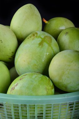 Siyah arka plan üzerinde sepet içinde taze yeşil mango