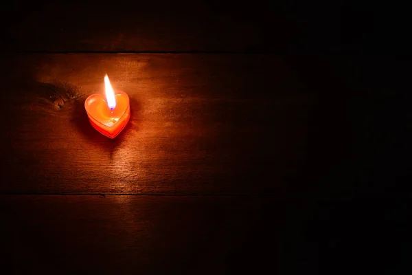 Close Up of burning red candle heart on dark background — Stock Photo, Image