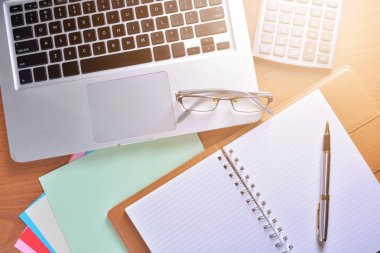 Defter ile hesap makinesi, klavye ve kalem masada