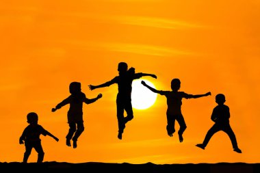 Oğlan ve kız günbatımı üzerinde atlama silüeti