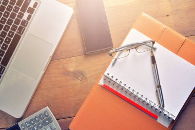 Defter ile hesap makinesi, klavye ve kalem masada