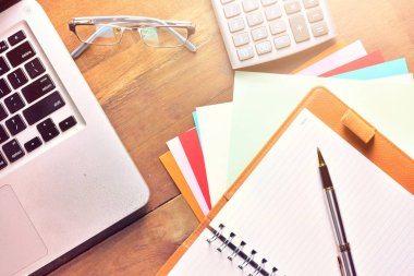 Defter ile hesap makinesi, klavye ve kalem masada