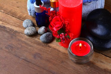 Kırmızı romantik mum ve spa yağı ile ahşap masa üzerinde havlu ve zen stone