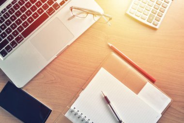 Defter ile hesap makinesi, klavye ve kalem masada