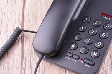 Ahşap masa üzerinde siyah telefon