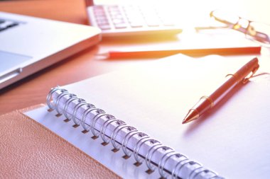 Defter ile hesap makinesi, klavye ve kalem masada