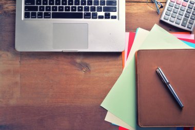 Defter ile hesap makinesi, klavye ve kalem masada