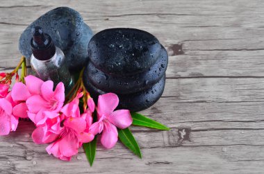 Özü yağı ve ahşap arka plan üzerinde zen taşlı çiçek