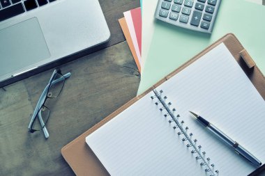 Defter ile hesap makinesi, klavye ve kalem masada
