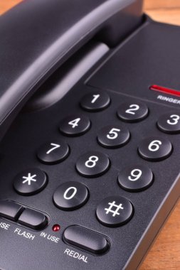 Ahşap masa üzerinde siyah telefon