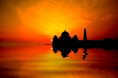 Asian görüntü günbatımı üzerinde su yansıması ile bir cami