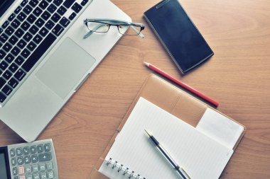 Defter ile hesap makinesi, klavye ve kalem masada