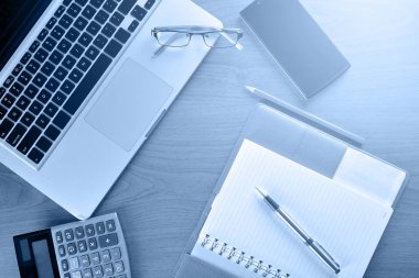 Defter ile hesap makinesi, klavye ve kalem masada