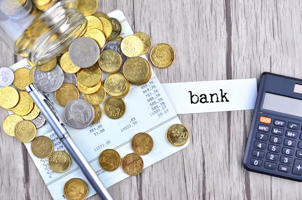 Coins, calculator and pen on bank account book with label bank