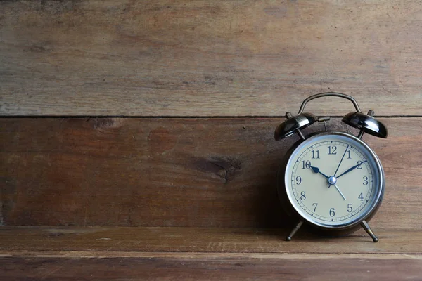 Retro alarm clock on wood background