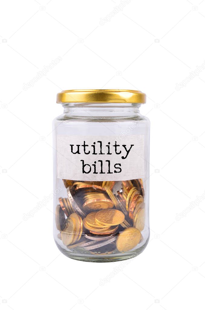 Coins in bottle with label Utility Bills isolated on white background - financial concept