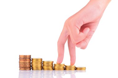 beyaz zemin üzerinde sikke yığını üzerinde yürüyen parmaklar. büyüme