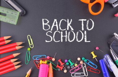 Okula Dönüş metni ile tebeşir tahtasında okul malzemeleri