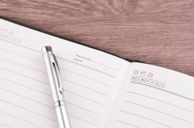 Kalem ve ahşap masa üstünde not etmek