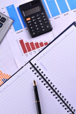 Boş defter ile hesap makinesi, klavye ve grafikler, çizelgeler ve iş tablo üzerinde dolma kalem. İş yerinde iş adamları