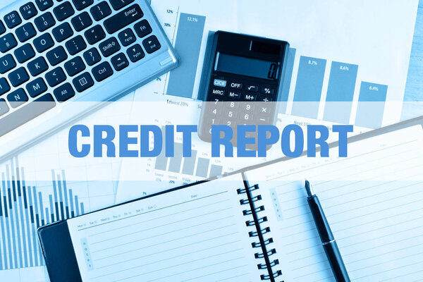 Ноутбук с калькулятором, клавиатурой и ручкой на столе
