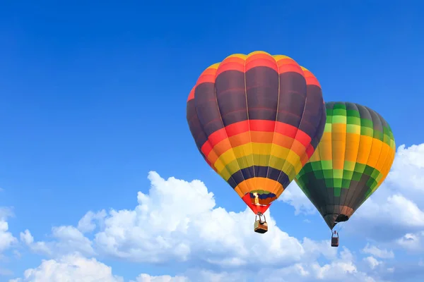 Kleurrijke hete lucht ballonnen in vlucht over blauwe hemel — Stockfoto
