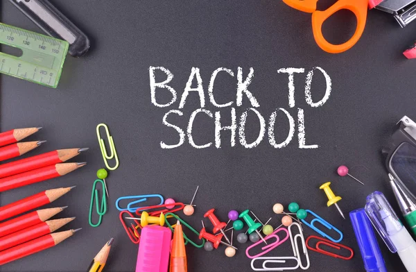 Okula Dönüş metni ile tebeşir tahtasında okul malzemeleri