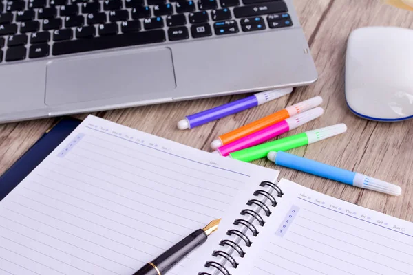 Laptop, notebook with magnifying glass on wooden table