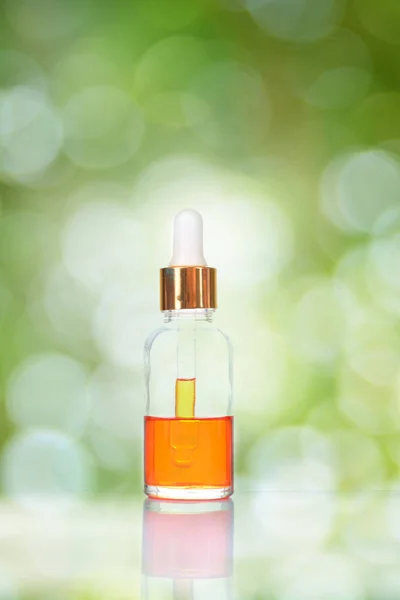 Orange Flüssigkeit Auf Flasche Über Grünem Bokeh Hintergrund — Stockfoto