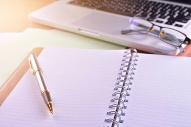 Defter ile hesap makinesi, klavye ve kalem masada