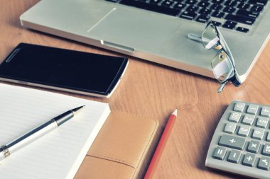 Defter ile hesap makinesi, klavye ve kalem masada