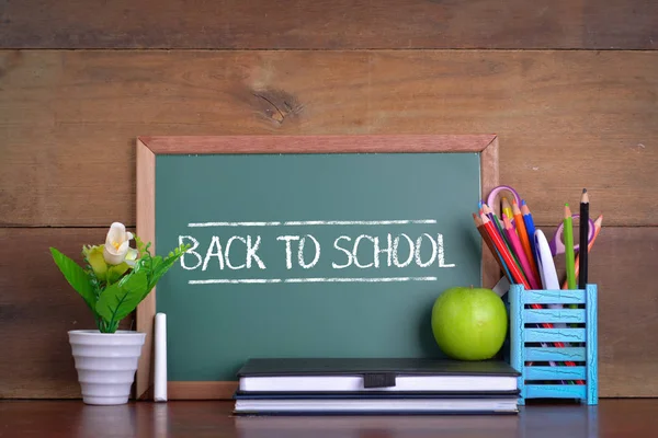 Tillbaka till skolan koncept med äpple på bordet framför chalkboar — Stockfoto