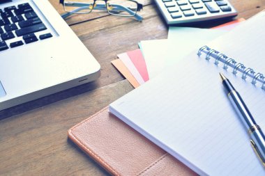 Defter ile hesap makinesi, klavye ve kalem masada