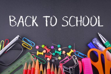 Okula Dönüş metni ile tebeşir tahtasında okul malzemeleri