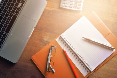 Defter ile hesap makinesi, klavye ve kalem masada