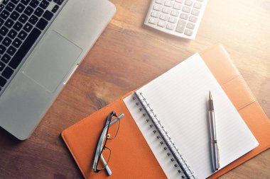 Defter ile hesap makinesi, klavye ve kalem masada