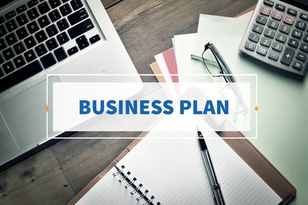Notebook and Laptop with text BUSINESS PLAN