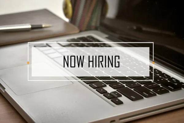 Notebook and Laptop with text NOW HIRING