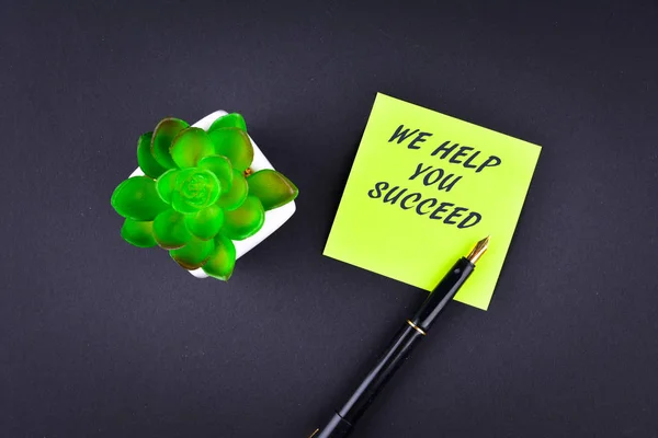 Nota verde adesiva con penna con testo Ti aiutiamo a successo — Foto Stock