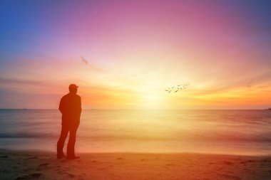 Sırasında altın günbatımı güzel gökyüzüne bakarak bir adam silüeti