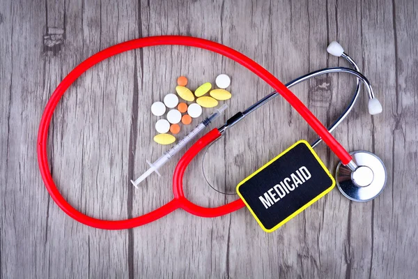 Pills, Şırınga ve Stetoskop metin Medicaid ile