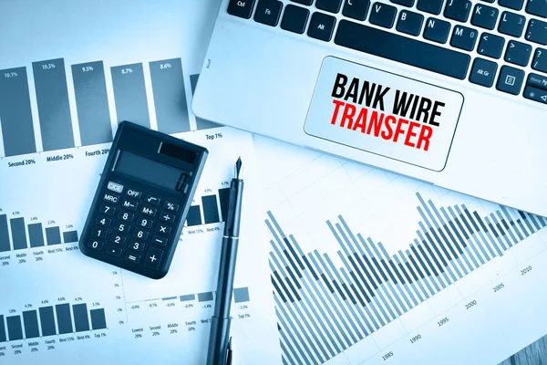 Графики, графики и клавиатура с текстом BANK WIRE TRANSFER — стоковое фото