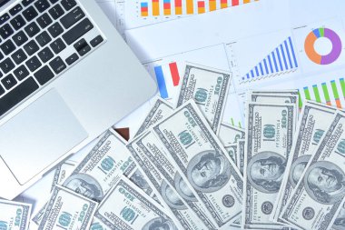 İş kavramı. Dizüstü bilgisayar, grafik ve banknot dolarları defter ve kalemle